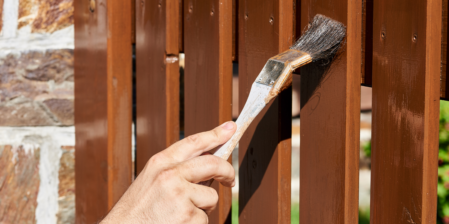 Paint brush painting garden fence